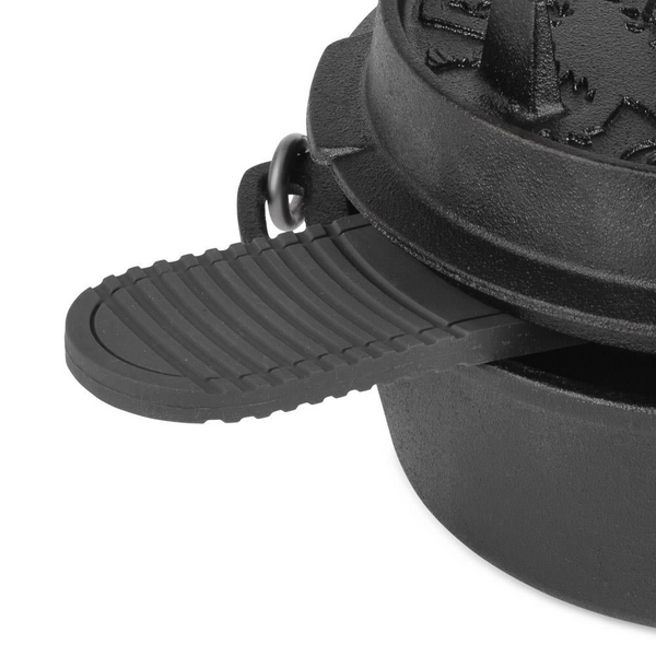 Schwarzer Petromax Silikonuntersetzer unter einem Gusseisen-Feuertopf