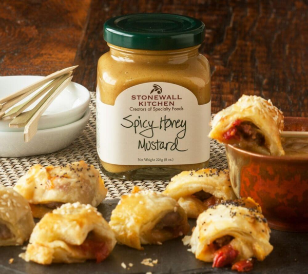 Stonewall Kitchen Spicy Honey Mustard im Glas neben Blätterteiggebäcken und Sauce