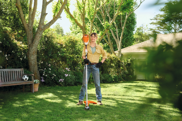 Frau in Garten mit Stihl FSA 80 R Motorsense bereit für Rasenpflege