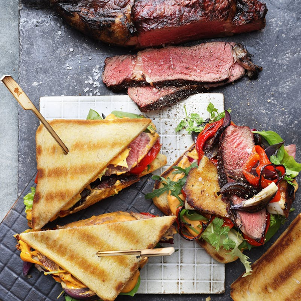 Gegrilltes Rindersteak und Sandwiches auf dunkler Steinplatte