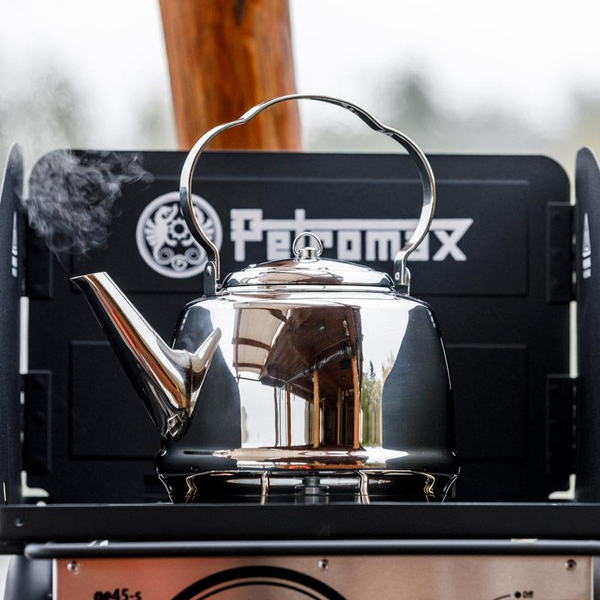 Petromax Teekessel auf Outdoor-Kocher mit sichtbarem Dampf und Markenlogo