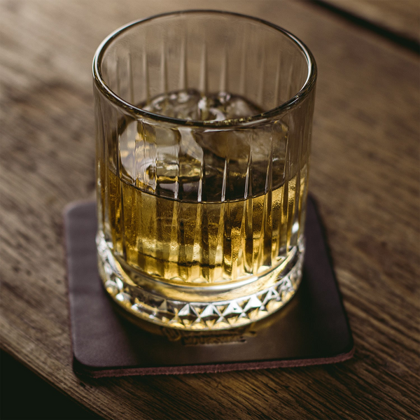 Whiskyglas auf dunkelbraunem Ledercoaster mit Herstellerlogo