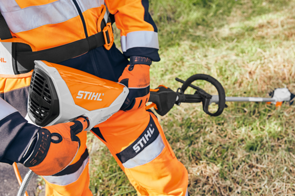 Person in STIHL Schutzausrüstung bedient Motorsense im Freien