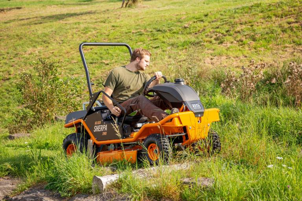 Mann bedient AS 920 Sherpa 2WD Aufsitzmäher in grüner Landschaft