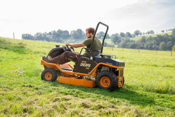 Mann bedient AS 920 Sherpa 2WD Aufsitzmäher auf sonniger Wiese
