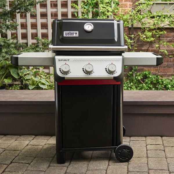 Weber SPIRIT E-310 Gasgrill auf Terrasse mit grüner Gartenkulisse
