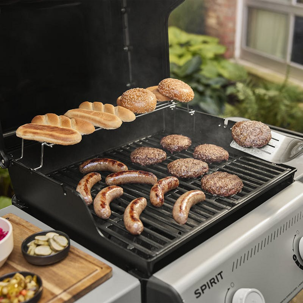 Weber SPIRIT E-310 Gasgrill in Betrieb mit Würsten, Burgern und Brot
