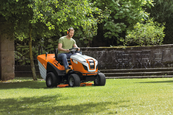 Mann benutzt STIHL RT 6127 ZL Aufsitzmäher in einem grünen Garten