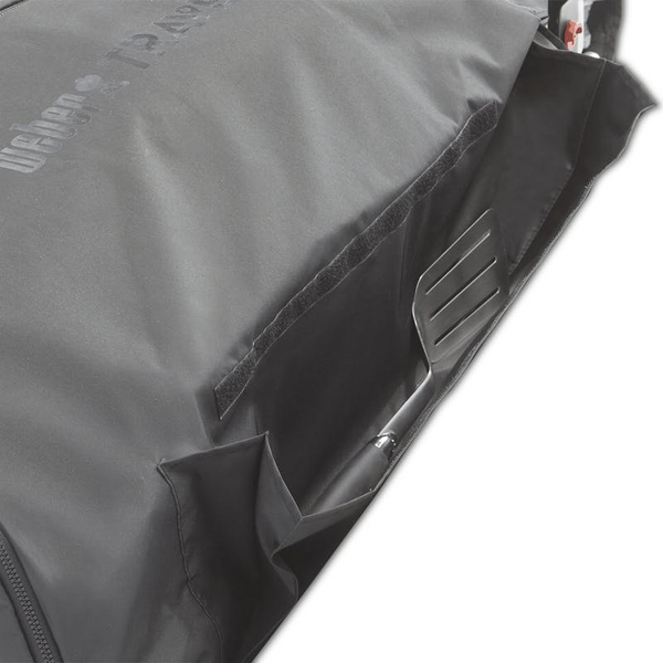 Detailansicht des Weber Traveler Kofferraumschutzes mit Grillzange in Aufbewahrungsfach