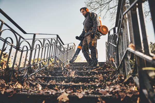 Mann verwendet Stihl BGA 300 Laubbläser auf herbstlicher Treppe