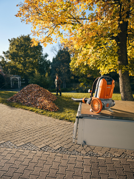 Mann verwendet Stihl BGA 300 Laubbläser im herbstlichen Garten
