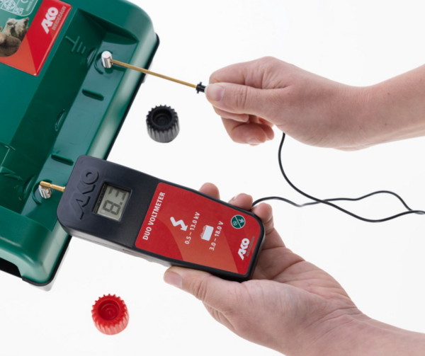 Hand hält AKO DUO-Voltmeter zur Spannungsmessung an einem Weidezaungerät