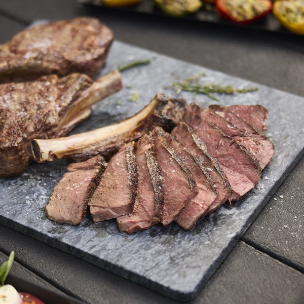 Perfekt gegrilltes, in Scheiben geschnittenes Steak auf Schieferplatte