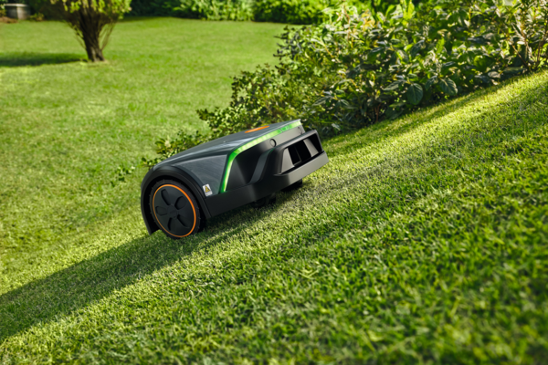 STIHL iMOW 3 EVO Mähroboter im Einsatz auf grünem Rasen neben Hecke