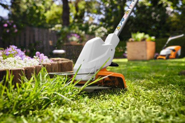 Stihl FSA 30 Akku-Motorsense schneidet Gras in sonnigem Garten