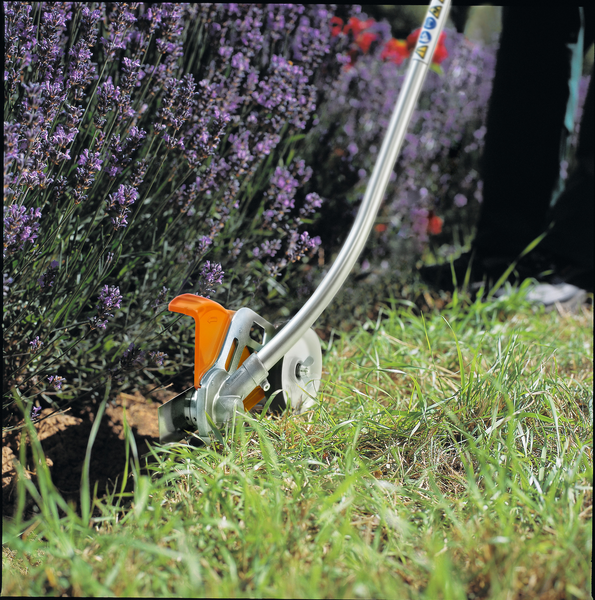 STIHL Kantenschneider im Einsatz bei der Pflege von Rasenkanten in einem blühenden Garten