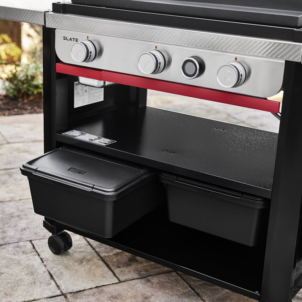 Weber Works Outdoor-Aufbewahrungsbox unter einem Weber SLATE Grill auf einer Terrasse