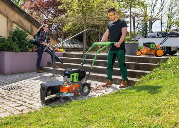 Mann und Frau bei Gartenarbeit mit Wildkrautentferner und Laubbläser
