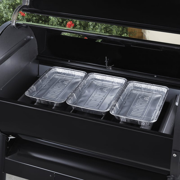 Drei leere Weber Wet-Smoke-Kits Wasserschalen auf einem schwarzen Grill