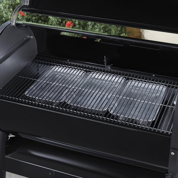 Schwarzer Weber Grill mit installiertem Wet-Smoke-Kit und leerem Rost im Freien
