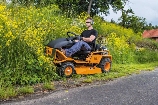 Mann fährt AS 900 Enduro Aufsitzmäher auf ländlicher Straße neben hohem Gras