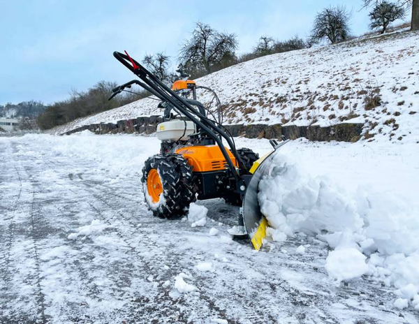 AS 600 MultiPro mit Schneeräumschild räumt Schnee auf einer Straße