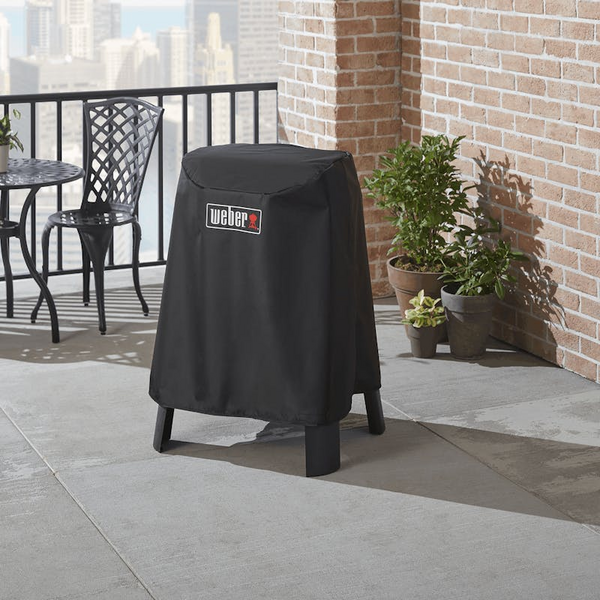 Weber Premium Abdeckhaube schützt Lumin Elektrogrill auf städtischer Terrasse