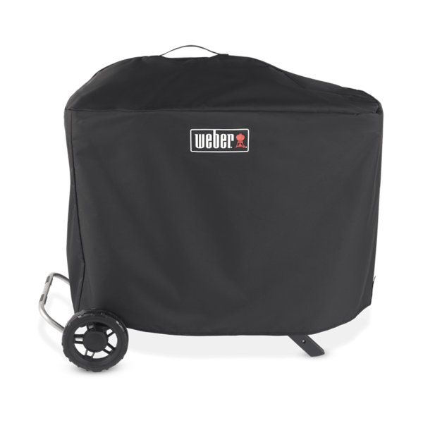 Schwarze Weber Traveler Premium Abdeckhaube über einem Grill mit sichtbarem Weber-Logo