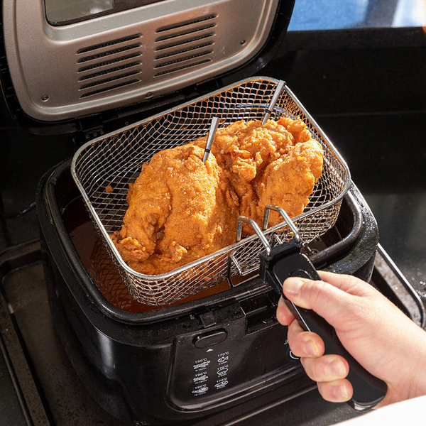 Person verwendet MEATER Pro XL Thermometer in elektrischer Fritteuse mit Hähnchen