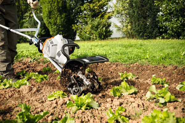 Person verwendet Stihl BK-MM Bodenkrümler im Garten zur Bodenbearbeitung