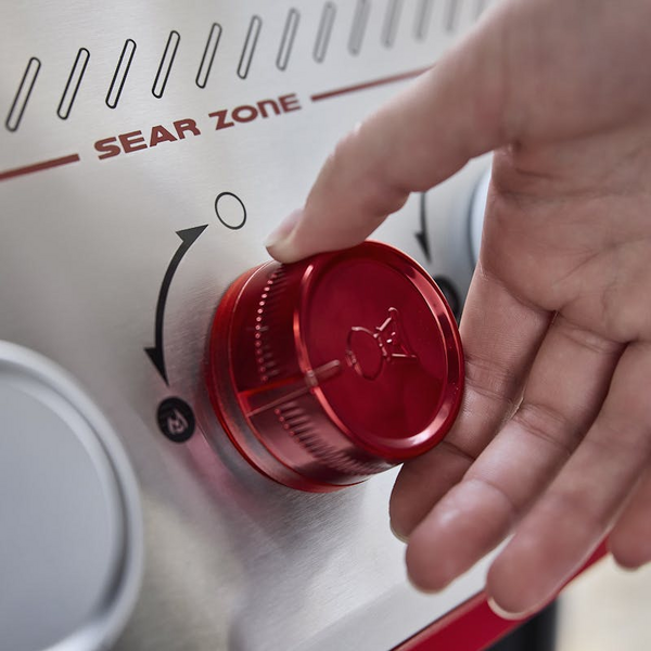 Hand bedient roten Drehknopf an Weber Gasgrill Sear Zone