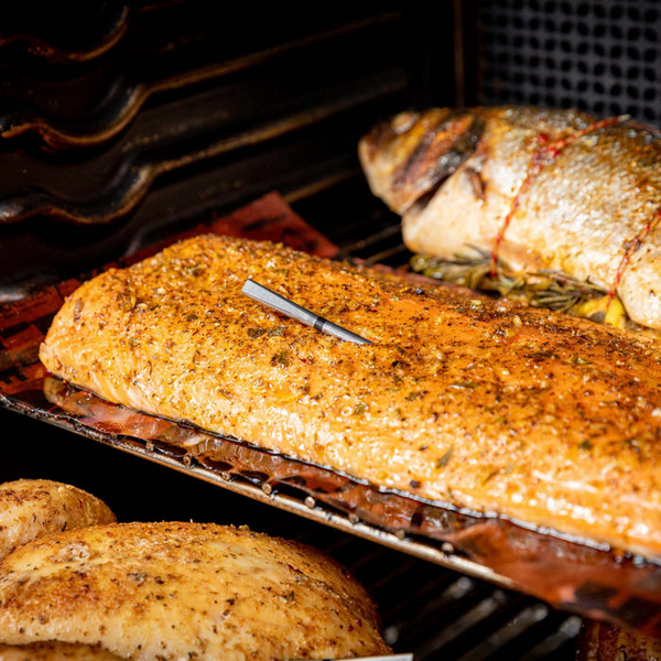MEATER Pro Thermometer in gewürztem Fleisch auf einem Grill