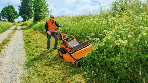 Mann bedient AS 901 SM Schlegelmulcher auf Hang neben Weg