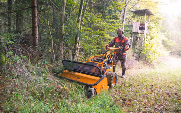 Mann bedient AS 901 SM Schlegelmulcher in bewaldeter Landschaft