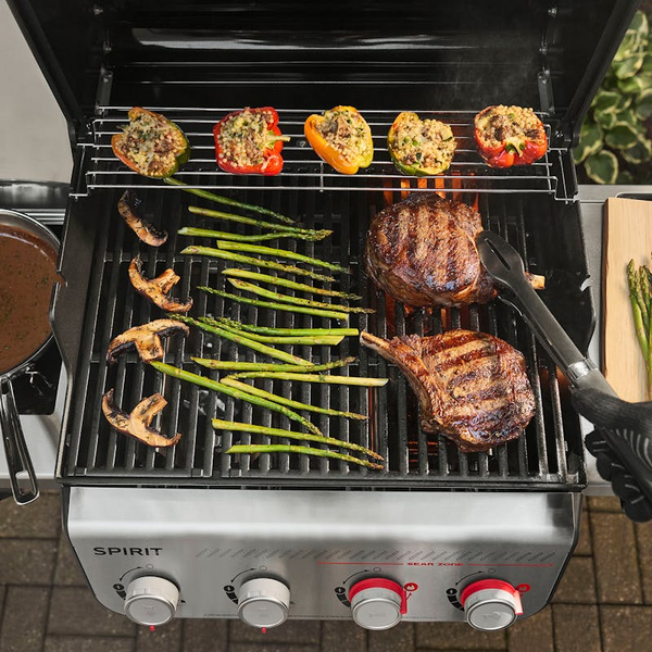Weber SPIRIT EX-435 Gasgrill mit Steaks, Spargel und gefüllten Paprikas auf Gusseisenrosten