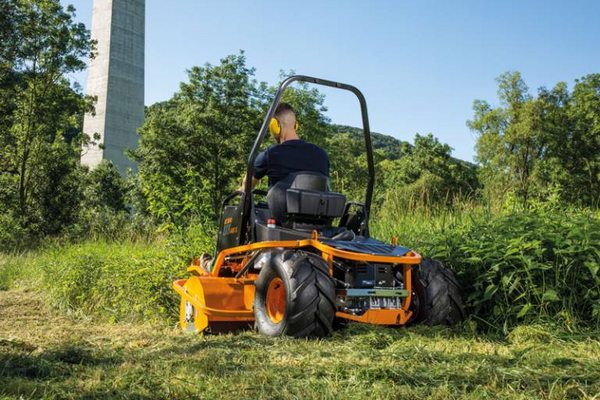 Mann bedient AS 1040 YAK 4WD XL Aufsitzschlegelmäher in natürlicher Umgebung mit hohem Gras
