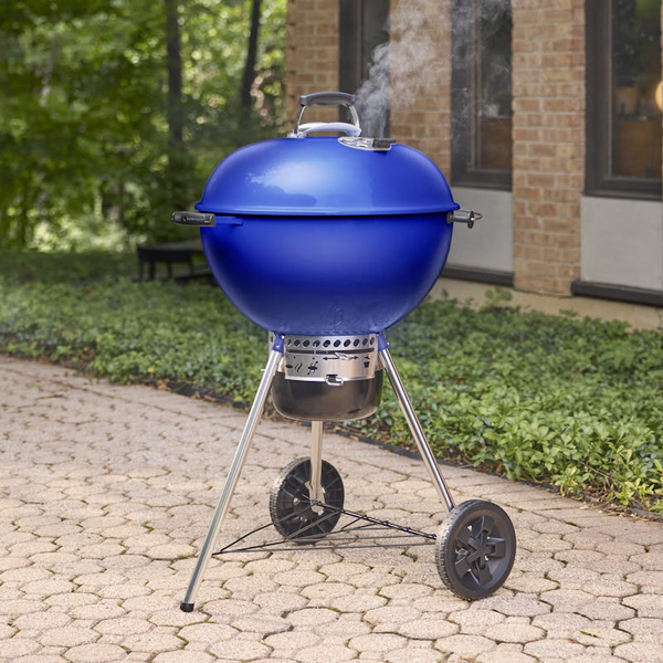 Weber Master-Touch GBS 5755 Holzkohlegrill in Ocean Blue auf einem gepflasterten Weg