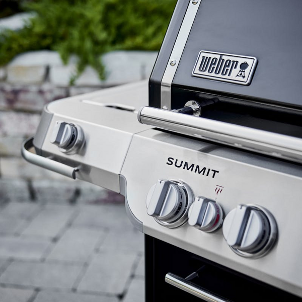 Nahaufnahme eines Weber Summit FS38 E Gasgrills mit Fokus auf Bedienelemente und Logo