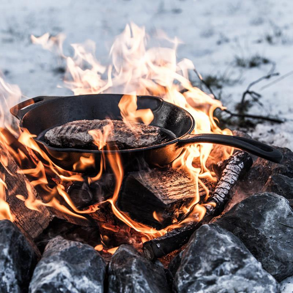 Gusseisen-Grillpfanne über offenem Feuer mit zwei Steaks