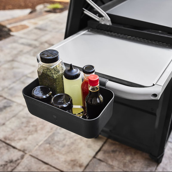 Weber Works Saucen- und Gewürzhalter befestigt an einem Grilltisch mit verschiedenen Saucen und Gewürzen
