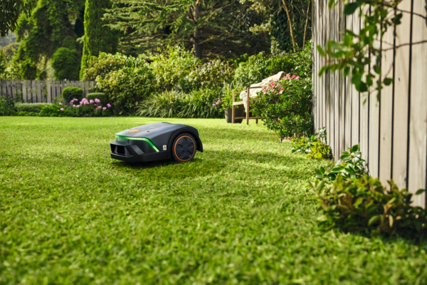STIHL iMOW 4 EVO Mähroboter im Einsatz auf grünem Rasen in einem blühenden Garten