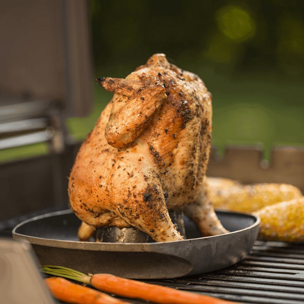Gegrilltes Hähnchen auf Weber Geflügelhalter umgeben von Mais und Karotten