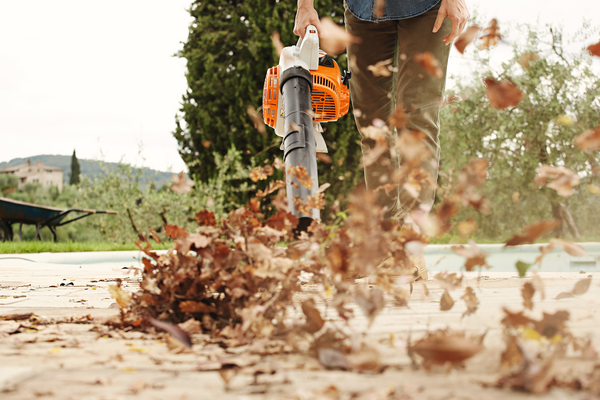 Person verwendet Stihl BG 56 Laubbläser in einem Garten