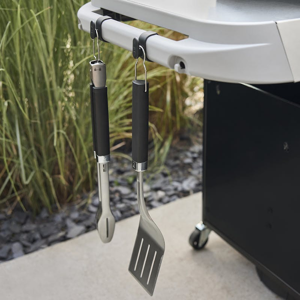 Grillwerkzeuge an Besteckhaken an einem modernen Weber Grill