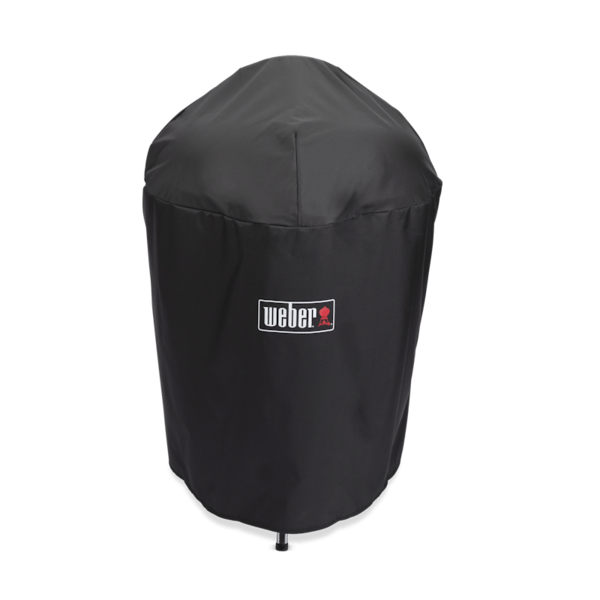 Schwarze Weber Premium Abdeckhaube für Holzkohlegrill auf grünem Hintergrund