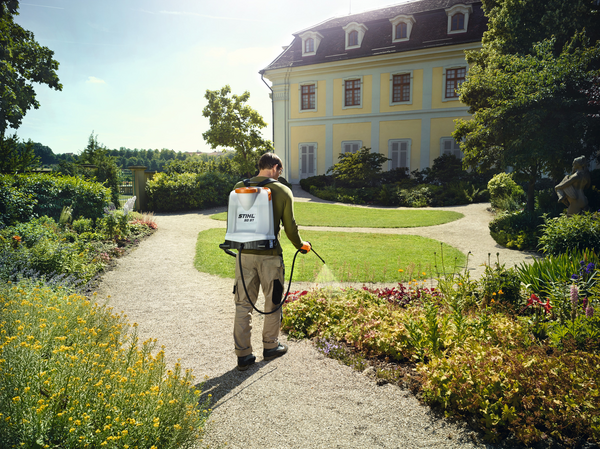 Person verwendet STIHL SG 51 Spritzgerät in sonnigem Garten