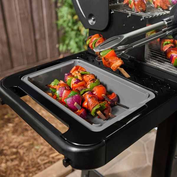 Seitentisch an einem Grill mit bunten Gemüse- und Fleischspießen
