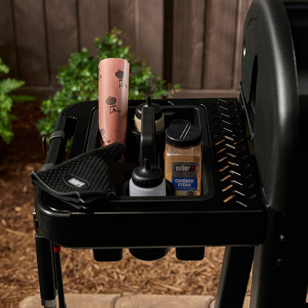 Weber Works Seitentisch mit Grillzubehör am schwarzen Grill