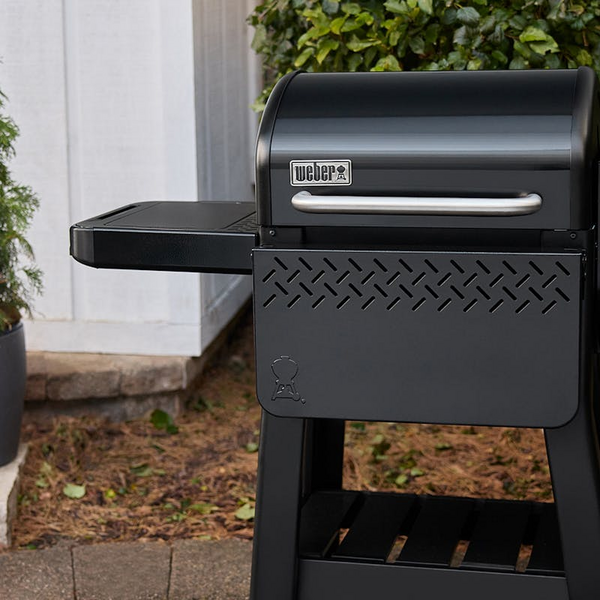 Weber Smoque Pelletsmoker mit angebrachtem Seitentisch im Freien
