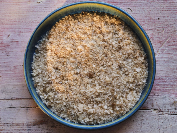 Nahaufnahme von Maldon Smoked Sea Salt in blauer Keramikschale auf Holzuntergrund